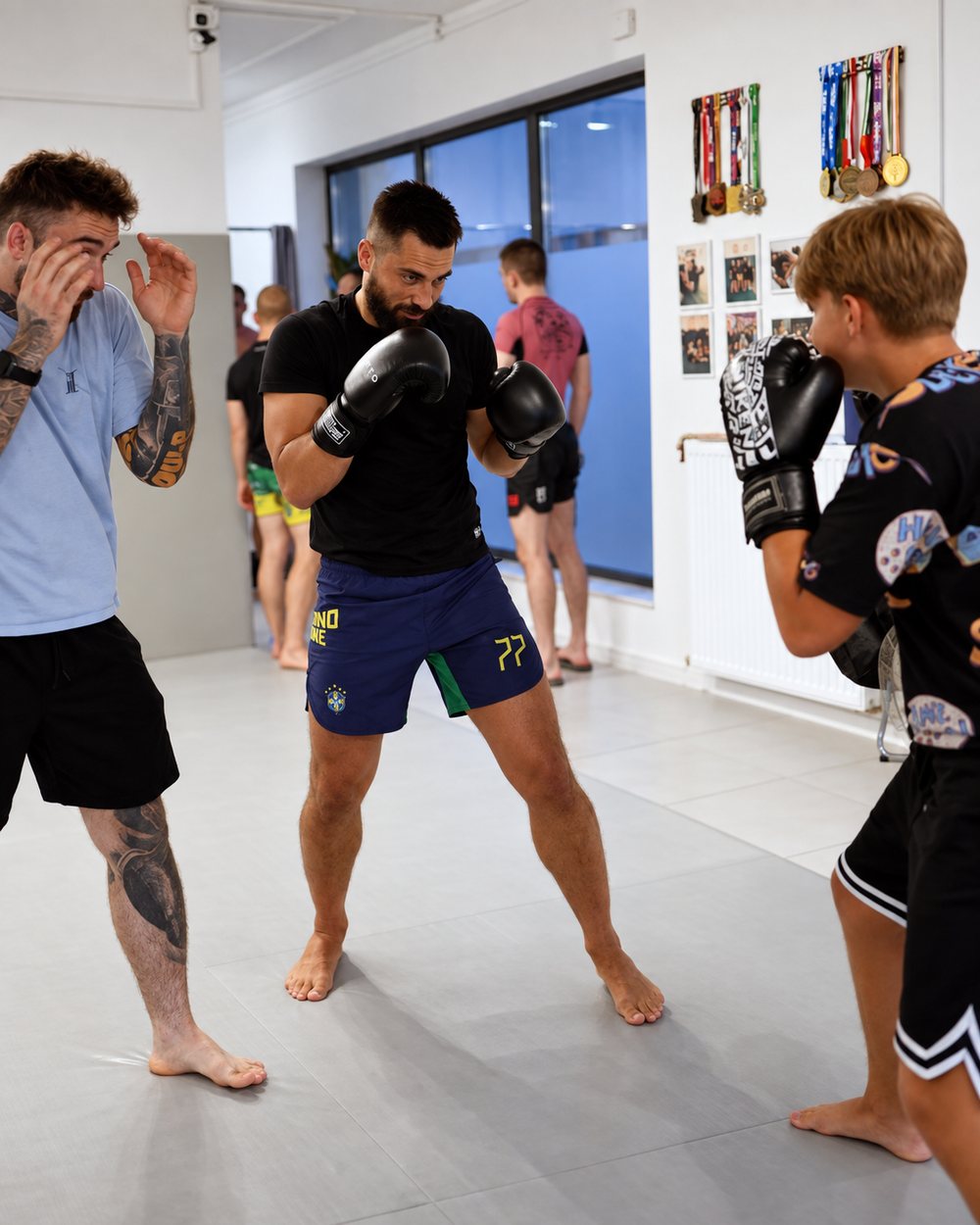 Uczestnicy treningu bokserskiego ćwiczą w parach z rękawicami